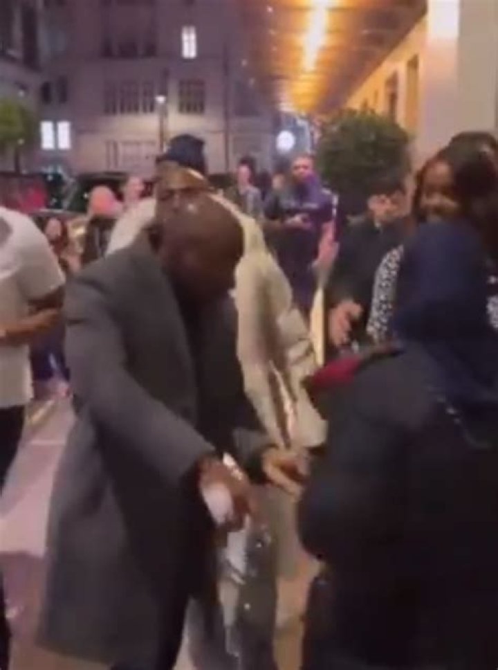 
Security prevents Davido from buying flowers from a woman as he walks the streets of London with Chioma 